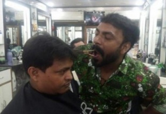 Photo. Հնդիկ վարսավիրը հաճախորդների մազերը կտրում է` մկրատը բերանում պահած